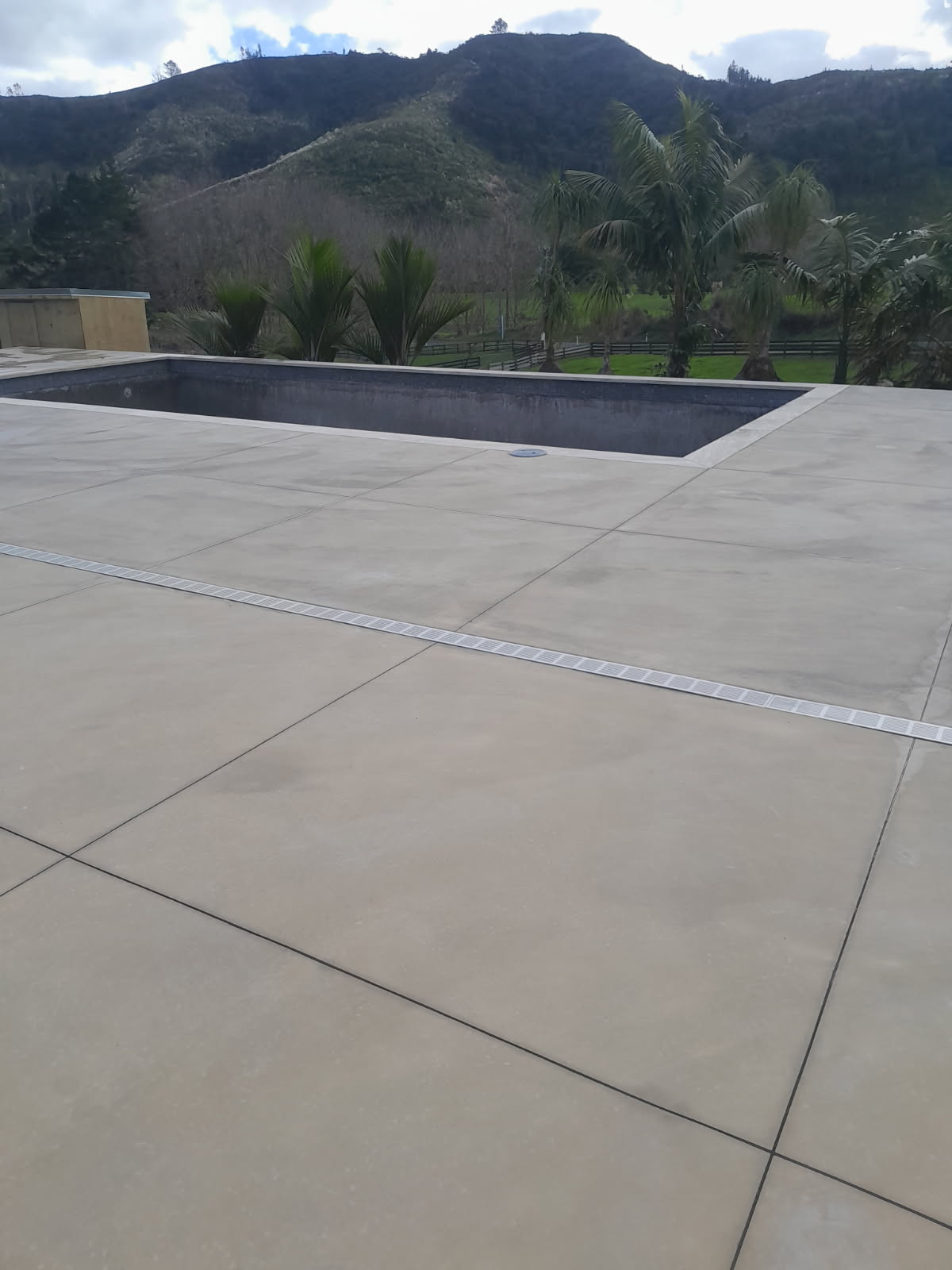 Coastline Concrete crew finishing a fresh concrete pour with a power trowel