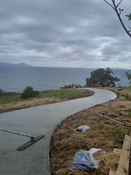Large concrete pad in front of a white country home